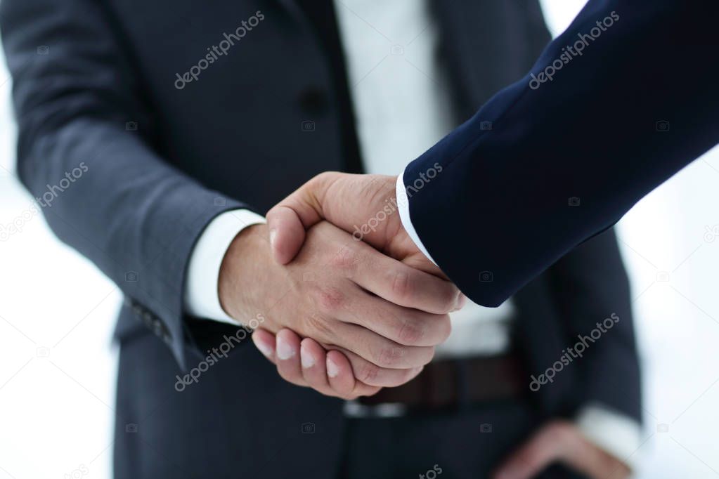 close up of two young male business partner shake hand