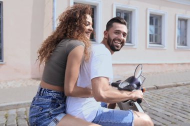 mutlu genç bir çift bir scooter üzerinde eğleniyor