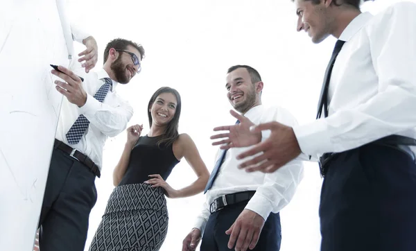 Hombre de negocios mostrando algo en una pizarra a sus colegas — Foto de Stock