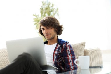 bir sehpa oturan bir dizüstü bilgisayar ile çok mutlu adam.