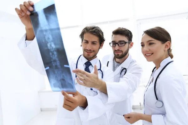Três médicos confiantes examinam um raio-X — Fotografia de Stock