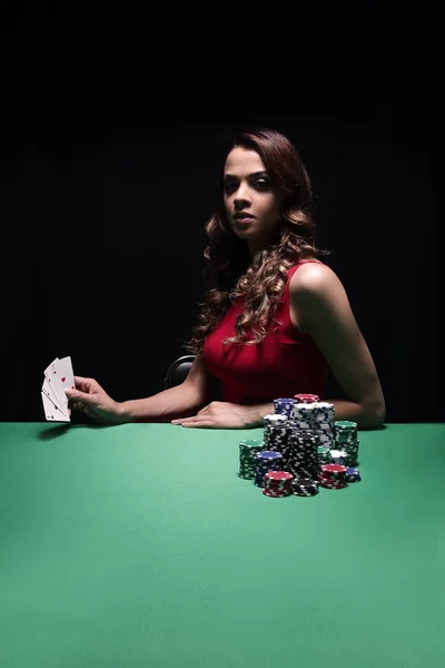 Pretty young woman gambling on green table — Stock Photo, Image