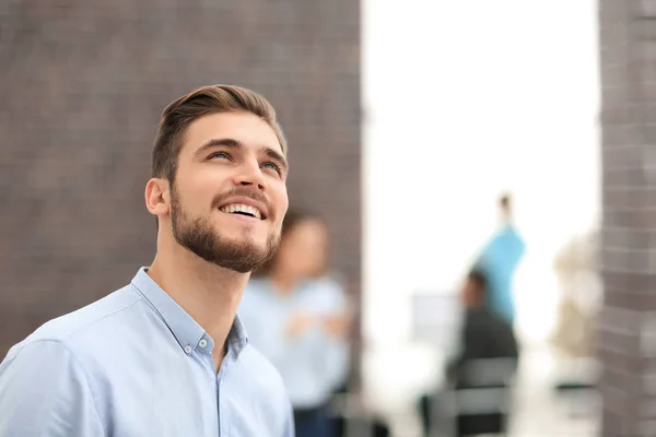 Uomo d'affari sorridente di profilo su sfondo ufficio , — Foto Stock