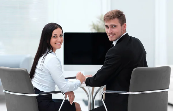 Dos empleados exitosos sentados detrás de un escritorio —  Fotos de Stock