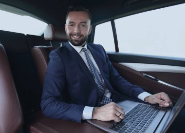 başarılı adam arabanın içinde otururken dizüstü bilgisayar ile çalışma