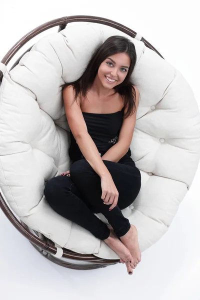 Smiling young woman resting in big soft armchair — Stock Photo, Image