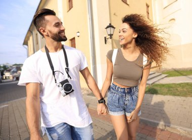 Bir çift şehrin sokaklarında yürüyor ve eğleniyor.