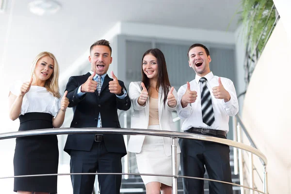 Business team står på terrassen och visar tummen upp. — Stockfoto