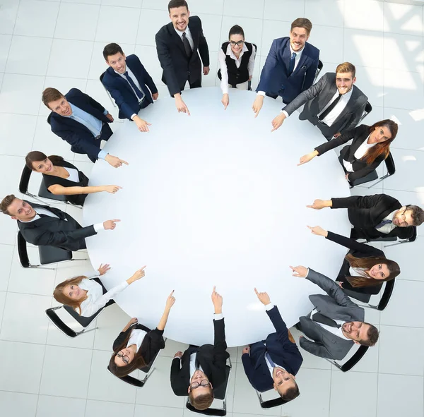 Closeup .business team wijzen in het midden van de tafel. — Stockfoto