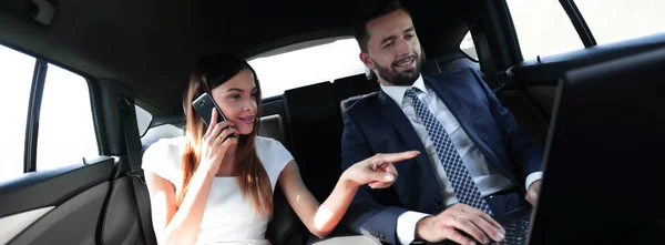 Forretningskvinne som snakker i telefonen i baksetet på bilen – stockfoto