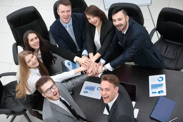 Equipo de negocios con las manos juntas en el escritorio — Foto de Stock