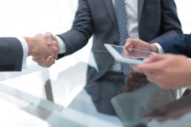 Bir toplantı sırasında el sıkışan iki emin iş adamları