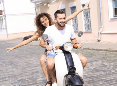 mutlu genç bir çift bir scooter üzerinde eğleniyor