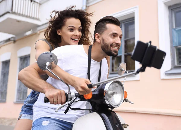 Pareja feliz en scooter haciendo selfie en el teléfono inteligente al aire libre —  Fotos de Stock