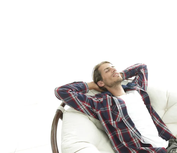 Modern guy is resting sitting in a large comfortable chair. side view. — Stock Photo, Image