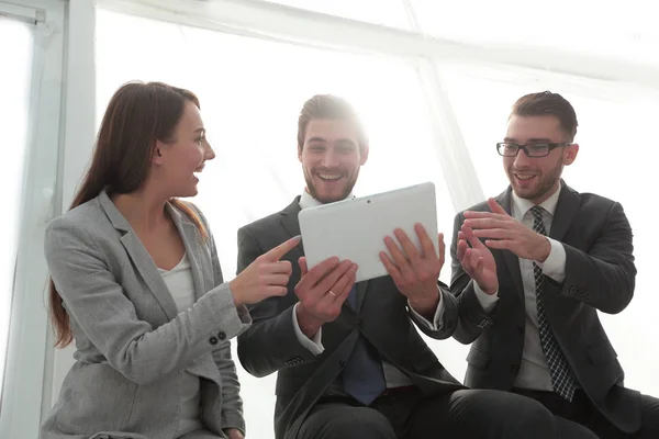 Três pessoas de negócios estão olhando para um tablet PC — Fotografia de Stock