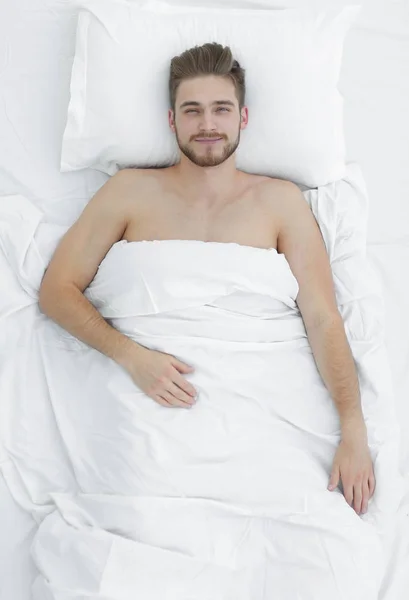 La vue du dessus. homme souriant couché sur le lit — Photo