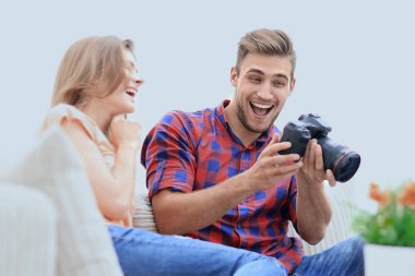 Modern genç çift gülüyor ve kameradaki fotoğrafları tartışıyor.