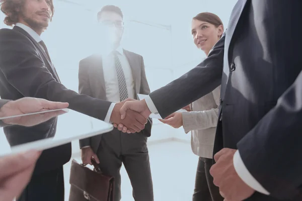 Employees look at the handshake business partners — Stock Photo, Image