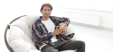 modern adam büyük bir rahat sandalyede oturuyor.