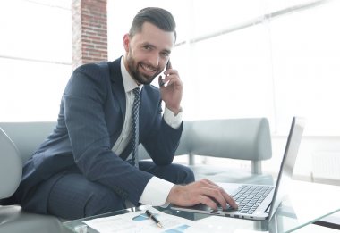 Smartphone üzerinde konuşmak ve metin dizüstü bilgisayarda yazarak işadamı