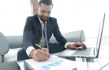 Dizüstü bilgisayarda çalışan ve Notlar not defterinde yapma şık adam