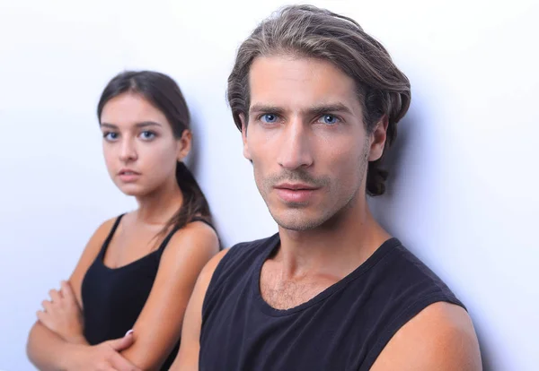 Serious young couple standing near the wall — Stock Photo, Image