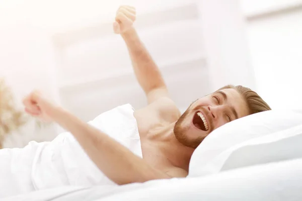 Homem feliz acordando em um quarto confortável — Fotografia de Stock