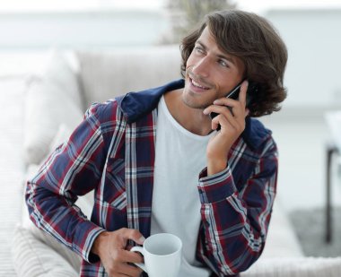 güzel bir fincan adamla bir dizüstü bilgisayar önünde oturur.