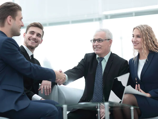 Partners concluding deal and shaking hands in the presence of team members — Stock Photo, Image