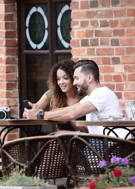 Genç bir çift bir kafe terasında oturup portresi