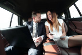 Mann und Frau diskutieren im Taxi über Arbeitspapiere