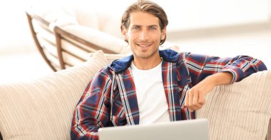 dizüstü bilgisayarda çalışan ve kameraya bakarak başarılı adam. Yukarıdan görüntülemek