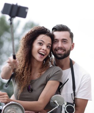 Erkek ve dişi bir kasabada motorlu scooter.