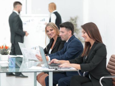 yeni bilgi tartışırken, açık belgili tanımlık laptop önünde duran iş takım