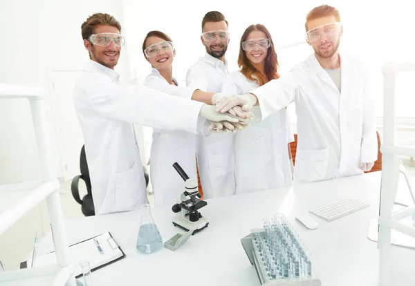 Επιτυχημένη ομάδα νέων επιστημόνων με τα χέρια ενωμένα μαζί. — Φωτογραφία Αρχείου
