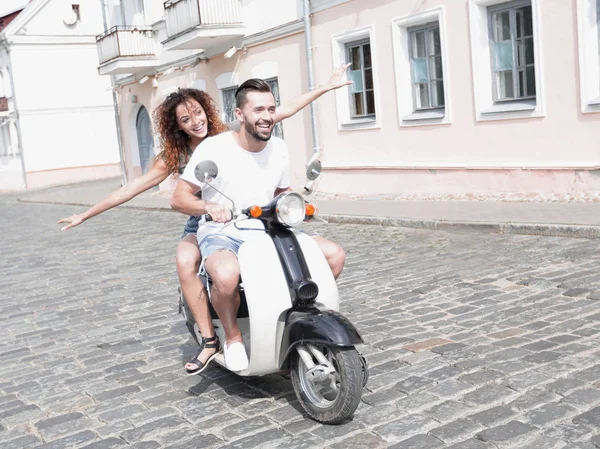 Felice giovane coppia divertirsi su uno scooter — Foto Stock