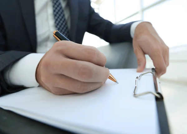 O empresário assina um contrato. Segurando a caneta na mão . — Fotografia de Stock