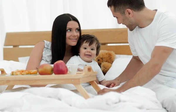 Família tomando café da manhã nutritivo na cama pela manhã — Fotografia de Stock