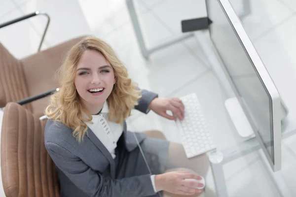 坐在办公桌后面的微笑的商业妇女 — 图库照片