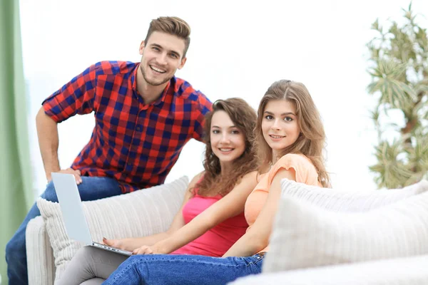 Grupp unga människor sitter i soffan i vardagsrummet. — Stockfoto