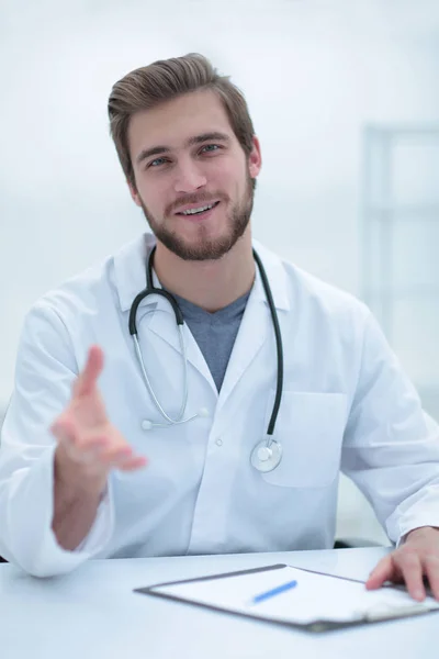 El guapo médico de bata blanca está ofreciendo su mano. — Foto de Stock