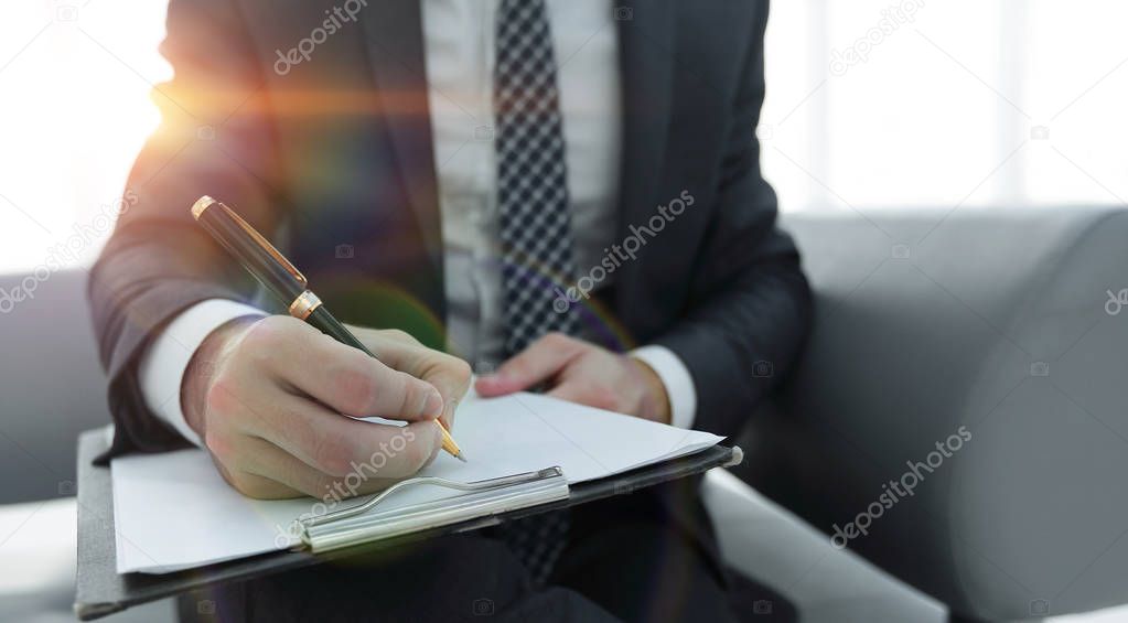 Businessman signs a contract. Holding pen in hand.