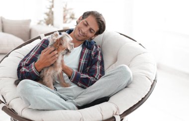 yakışıklı olan büyük bir koltukta oturan bir köpekle.