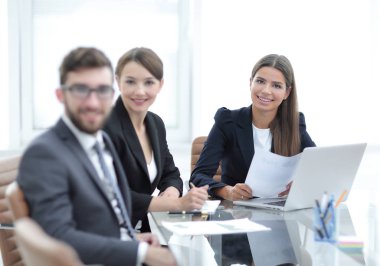 bir masanın arkasında oturan çalışanlar.