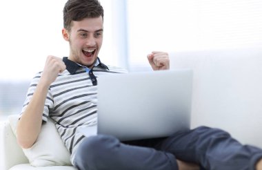 mutlu adam kanepede oturan dizüstü bilgisayar ile