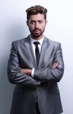 Çapraz kollarla poz veren genç iş adamı.