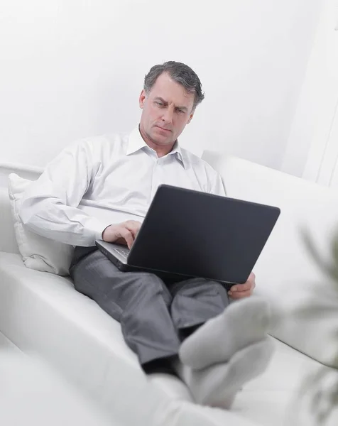 Uomo d'affari che lavora sul computer portatile mentre è seduto in una stanza d'albergo — Foto Stock