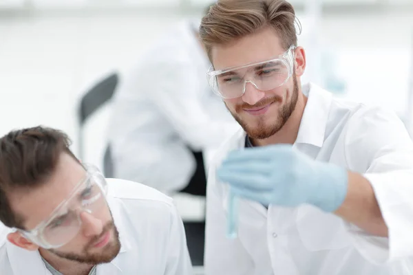 테스트 튜브에 액체를 검사 하는 두 과학자 — 스톡 사진