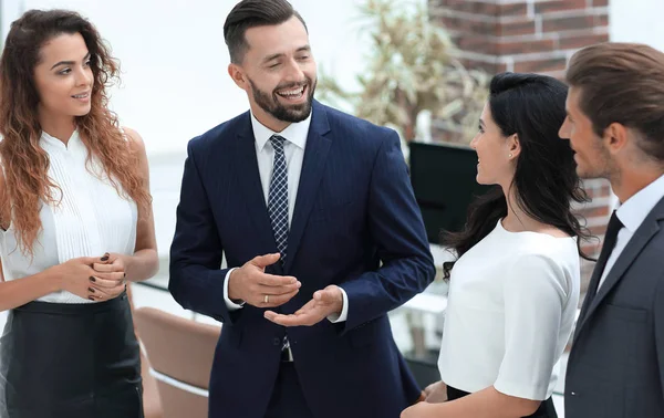 Sonriente equipo de negocios hablando, de pie en la oficina — Foto de Stock